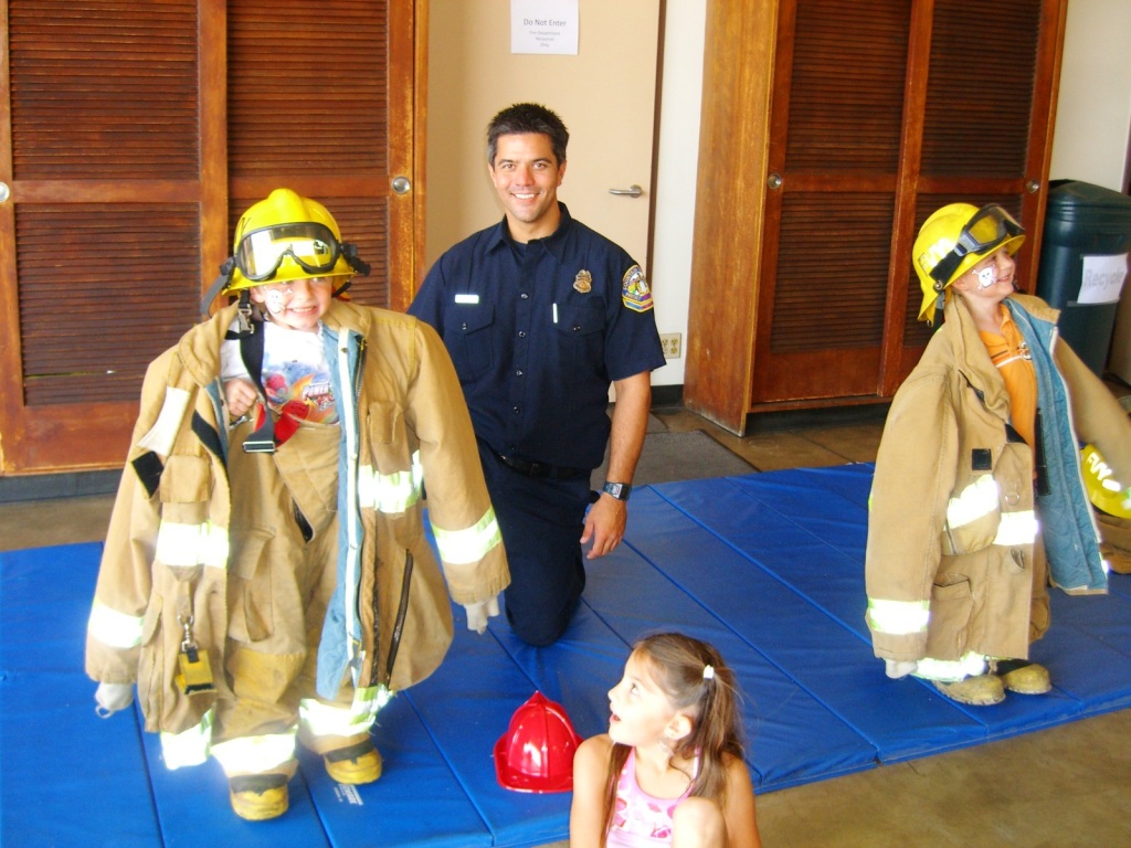 Children tyring on the firefighter uniform during